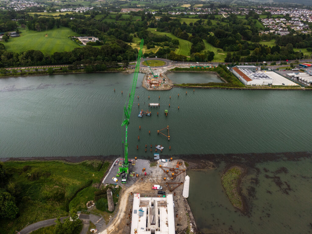 Aerial view of the south abutment of the Narrow Water Bridge and the line of temporary piles crossing the River Newry