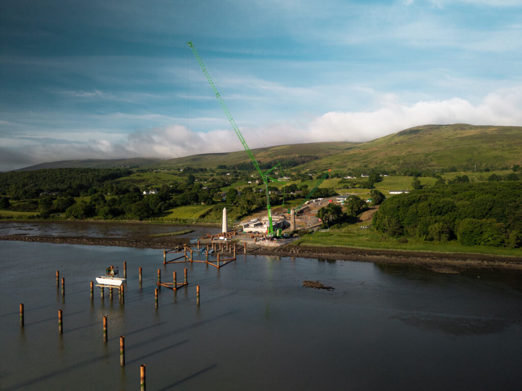 Temporary steel piles designed by AM Consulting Engineers and installed by Quinn Piling in the River Newry, with a crawler crane on the south bank